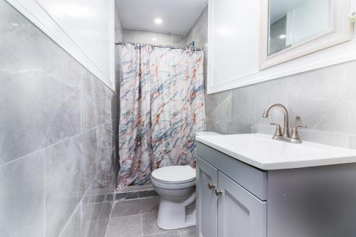 a bathroom with a toilet and a shower curtain at Quaint 1 Bedroom Apartment Sleeps 2-3, Near Niagara Falls in Niagara Falls