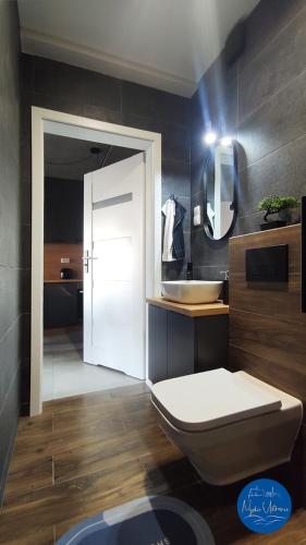 a bathroom with a white toilet and a sink at Nyskie Ustronie in Nysa