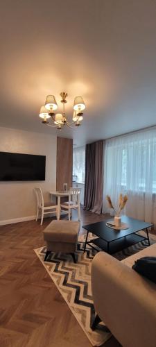 a living room with a couch and a table at Sunny Home Self check in & out in Šiauliai