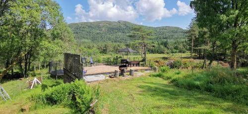 a garden with a picnic table in the middle of a field at Alone In The Woods With Your Own River Nearby in Fitjar