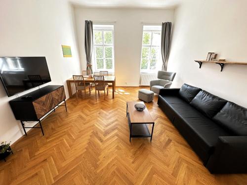 salon z czarną kanapą i stołem w obiekcie Black Eagle Apartments w Pradze