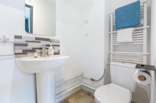 Baño blanco con lavabo y aseo en Cosy house 10P - 5 chambres -5 salles de bain - proche Lille et toutes commodités, en Roubaix