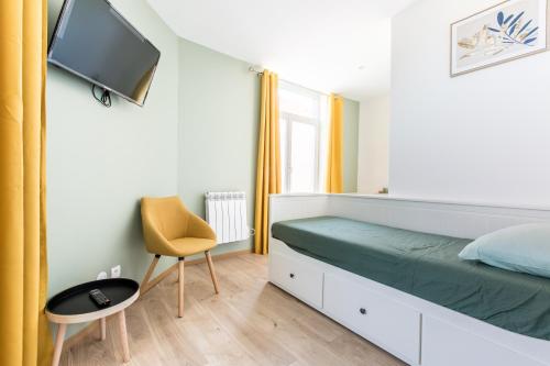1 dormitorio con 1 cama, TV y silla en Cosy house 10P - 5 chambres -5 salles de bain - proche Lille et toutes commodités, en Roubaix