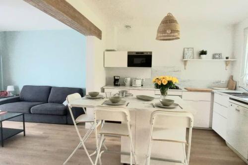 une table blanche et des chaises dans un salon dans l'établissement Maisonnette Au 15, à Auxerre