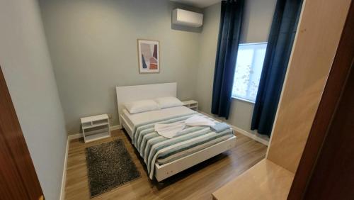 a small bedroom with a bed and a window at Cozy villa, Golem beach. in Golem