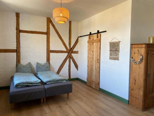 Zimmer mit Sofa und Scheunentür in der Unterkunft Gamle Præstegård in Fåborg