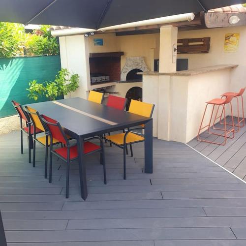 - une table et des chaises sur une terrasse avec un parasol dans l'établissement Joli haut de villa 3 chambres climatisé avec jacuzzi, à Marignane