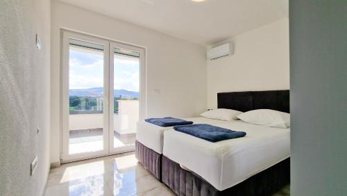 1 dormitorio con cama y ventana grande en Villa Apartments Marko & Šimun, en Kaštela