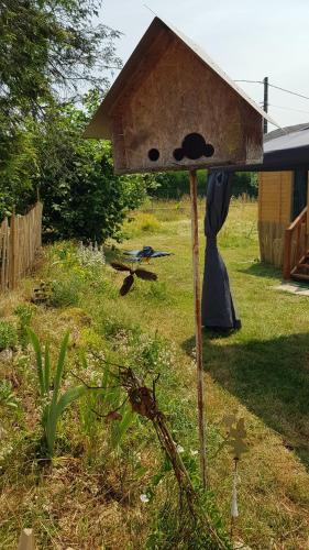 una casa de pájaros sentada en el césped en un patio en Roulotte goûteux de nature en Saint-Barthélemy