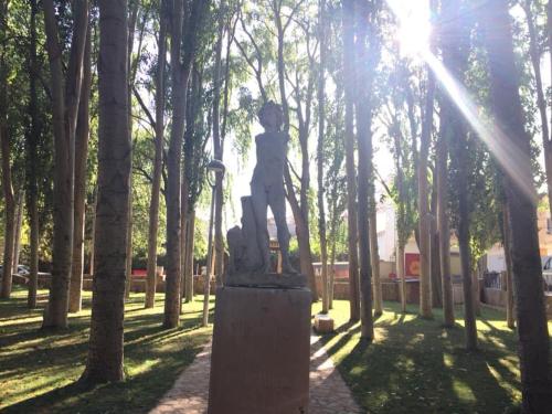 a statue of a boy standing on top of a park at LA CASA DEL CAMINO DEL PUERTO in Chirivel