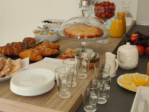 stół z talerzami i kieliszkami na stole z jedzeniem w obiekcie Sienda Cesira w mieście Muravera