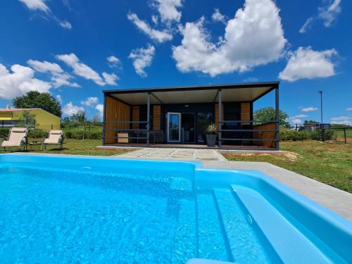 uma villa com piscina em frente a uma casa em Small country house em Manjadvorci