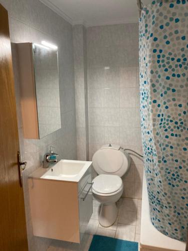 La salle de bains est pourvue de toilettes blanches et d'un lavabo. dans l'établissement Cozy Cottage at Flogita, à Flogita