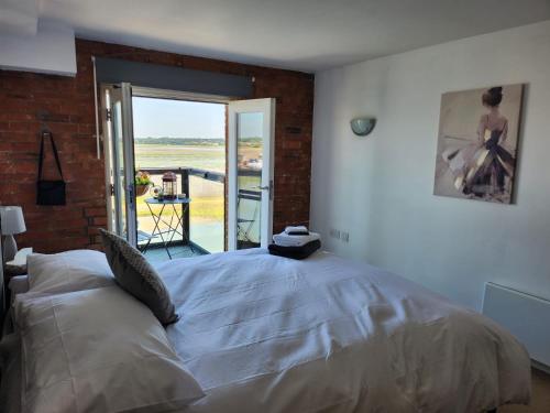 a bedroom with a bed and a brick wall at Holiday Let Mistley in Mistley