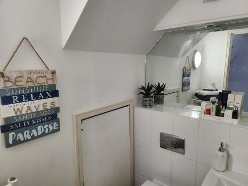 un baño con aseo y un letrero en la pared en Holiday Let Mistley, en Mistley