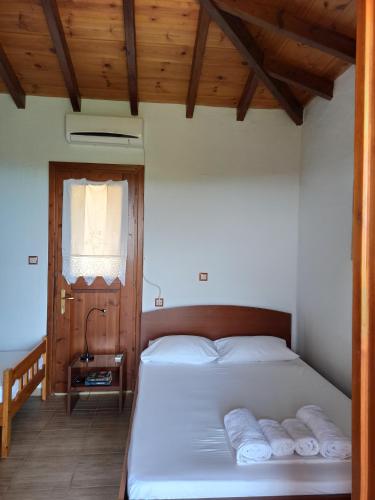 a bedroom with a bed with three pillows on it at Katerina's Houses #2 in Alonnisos Old Town
