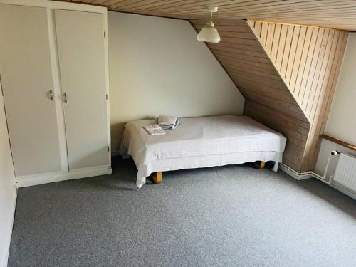 a small bedroom with a bed and a staircase at Nice House in centrum. in Frederikshavn