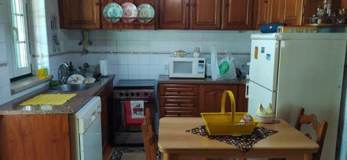 a kitchen with a table and a white refrigerator at Casa da Avó Bi in Vila Nova da Barquinha
