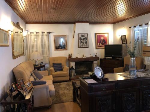 a living room with a couch chairs and a fireplace at Casa da Avó Bi in Vila Nova da Barquinha