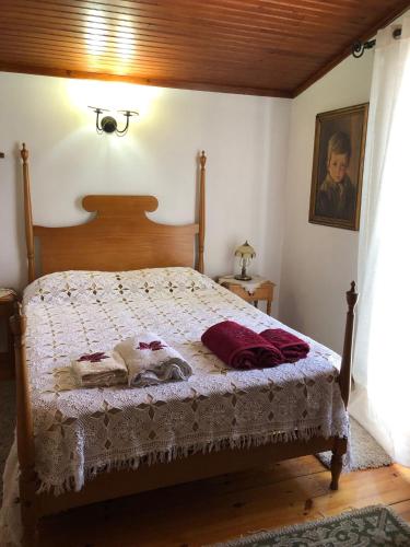 a bedroom with a bed with a wooden headboard at Casa da Avó Bi in Vila Nova da Barquinha