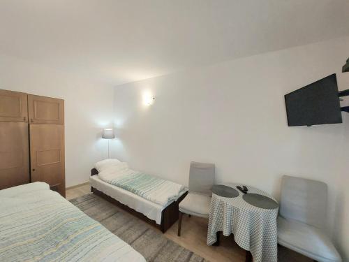Zimmer mit 2 Betten, einem Tisch und einem TV in der Unterkunft Kawalerka w centrum Sopotu in Sopot