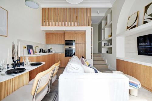 Il comprend un salon avec un canapé blanc et une cuisine. dans l'établissement Luxury apartment 5P1BR - Square des Batignolles, à Paris