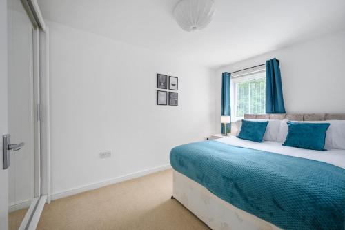 a bedroom with a bed with blue curtains and a window at Stunning Entire House 6 mins to Manchester City Centre, near Etihad stadium, Free Parking and Super Fast Wifi in Manchester