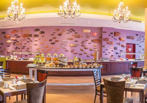 リロングウェにあるPresident Hotel at Umodzi Parkの食べ物が置かれたテーブルのあるダイニングルーム