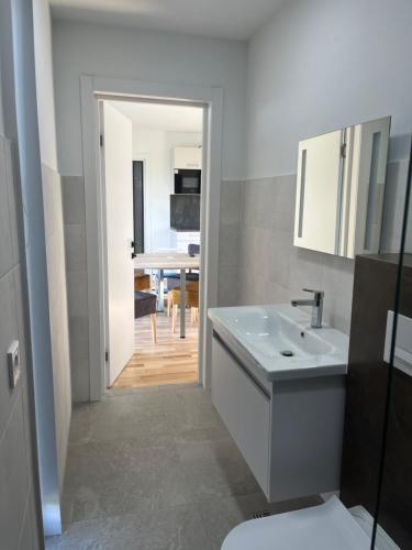 a bathroom with a white sink and a toilet at Haus PEAK am See in Zirkow