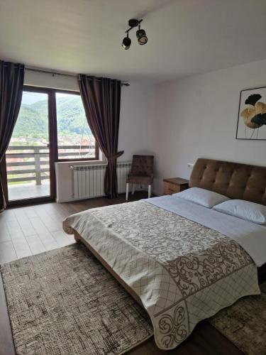 Un dormitorio con una cama grande y un balcón. en Agropensiunea La Uța, en Rebrişoara