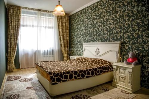 um quarto com uma cama num quarto com papel de parede verde em 2room apartment 100sq m With a Beautiful Mountain views em Almaty