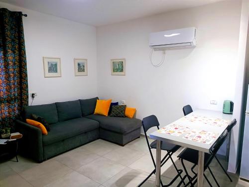 ein Wohnzimmer mit einer grünen Couch und einem Tisch in der Unterkunft On the sea in Aschkelon