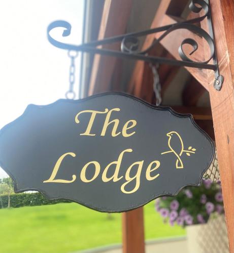 a black and gold sign that reads the lodge at The Lodge Donegal Town in Donegal