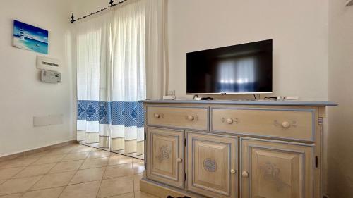 uma sala de estar com televisão em cima de uma cómoda em VILLA FRANCESCA em Tanaunella