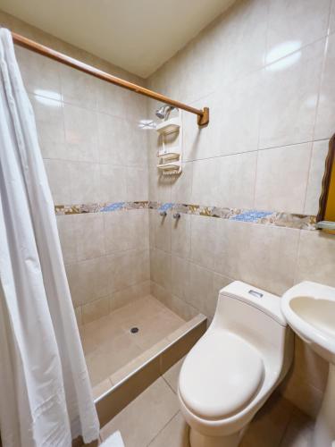 a bathroom with a shower and a toilet and a sink at Casa Huéspedes Pimentel in Pimentel