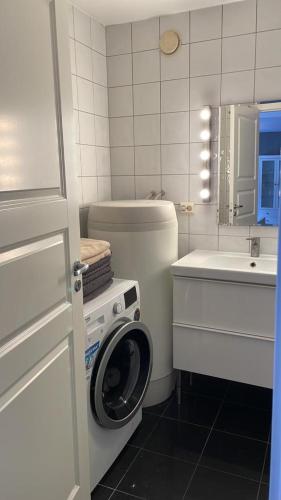 a bathroom with a washing machine and a sink at Eiganesveien 1/sentralt,2 sov. in Stavanger