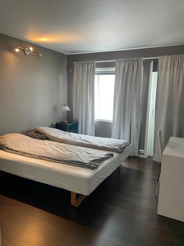 a bedroom with a large bed with a window at Eiganesveien 1/sentralt,2 sov. in Stavanger