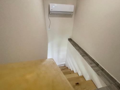 a room with a stairs with a air conditioner on the wall at Duplex Oasis Ada in Ada