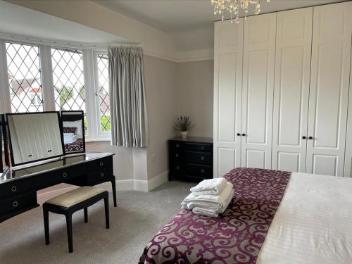 een slaapkamer met een bed, een dressoir en een bureau bij Walton House in Frinton-on-Sea