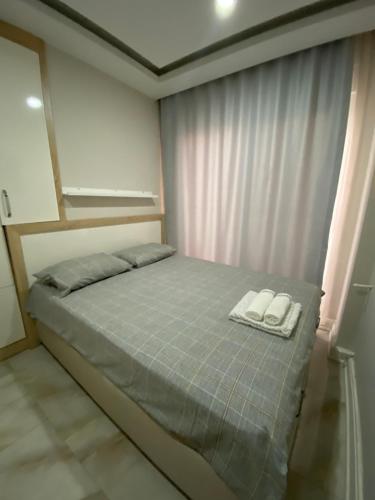 a bedroom with a bed with two towels on it at Lara Kundu Oteller Bölgesi in Aksu