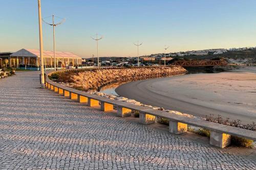 a road next to a beach with a bridge at Amazing Sea View Beach House in Lourinhã