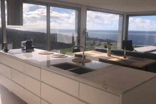 a kitchen with a sink and a view of the ocean at Amazing Sea View Beach House in Lourinhã