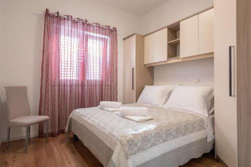 1 dormitorio con 1 cama con cortina rosa en Bugenvilija apartment, en Brna