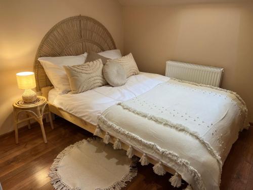 łóżko z białą pościelą i poduszkami w pokoju w obiekcie Apartament BohoLook w Nowym Sączu