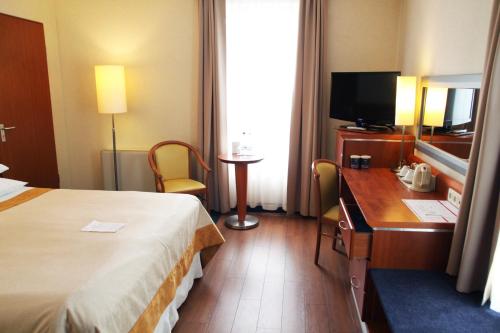 a hotel room with a bed and a desk and a television at Hotel Nadmorski in Gdynia