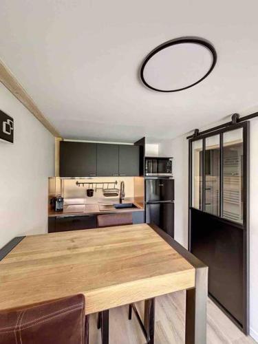 - une cuisine avec une grande table en bois dans l'établissement Petit loft chaleureux et cosy - vue montagne, à Guillestre