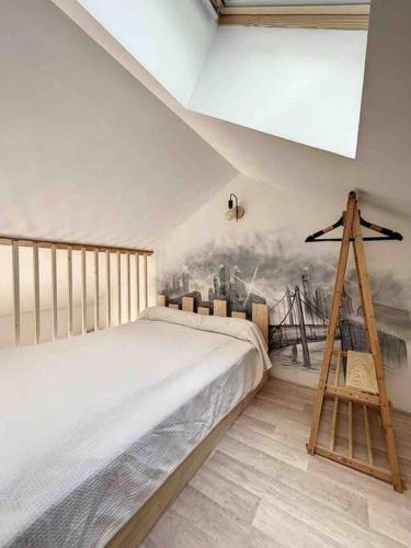 une chambre avec un lit et un tableau au mur dans l'établissement Petit loft chaleureux et cosy - vue montagne, à Guillestre