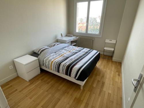 um quarto com uma cama e duas mesas e uma janela em T4 3 Chambres proche grattes ciel, Villeurbanne, meublé em Villeurbanne