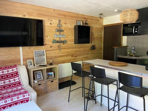 - une cuisine avec un comptoir et des chaises dans la chambre dans l'établissement Appartements au cœur de la station de ski 