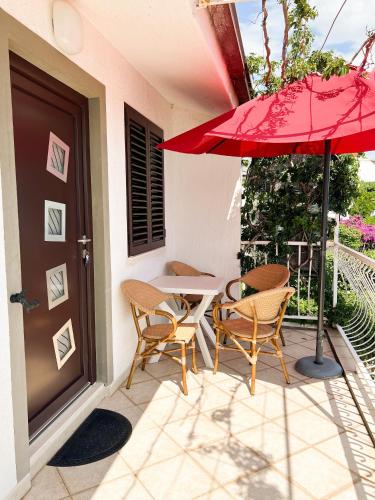 a patio with two chairs and a table with an umbrella at Apartments Vedran in Čelina